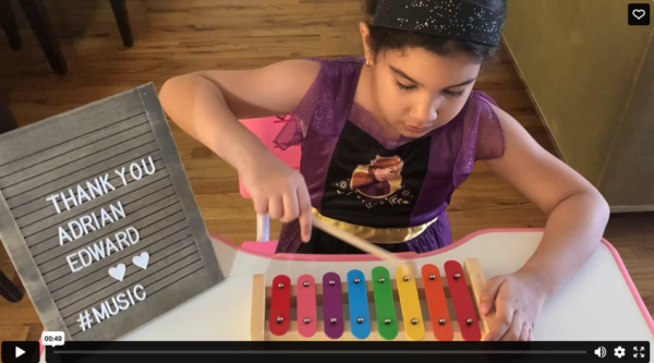 A girl is playing with an instrument on the table.